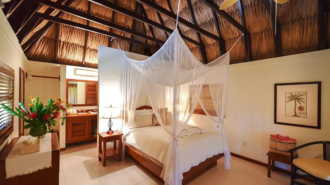 Bedroom in Casita with thatched roof at Victoria House Resort and Spa, Belize