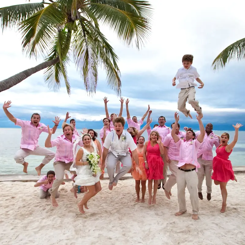Bridal party celebrating on the beach at Victoria House Resort and Spa